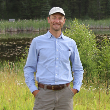 a man in a field wearing a cap