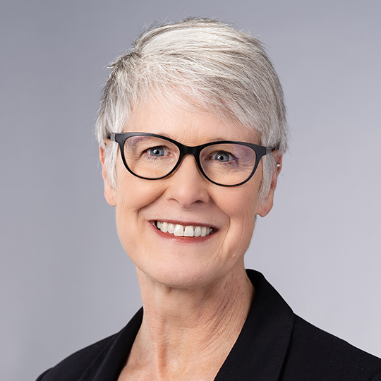 a woman with short gray hair and glasses
