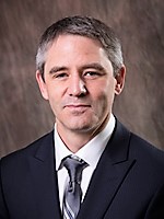 man with short gray hair wearing suit and tie
