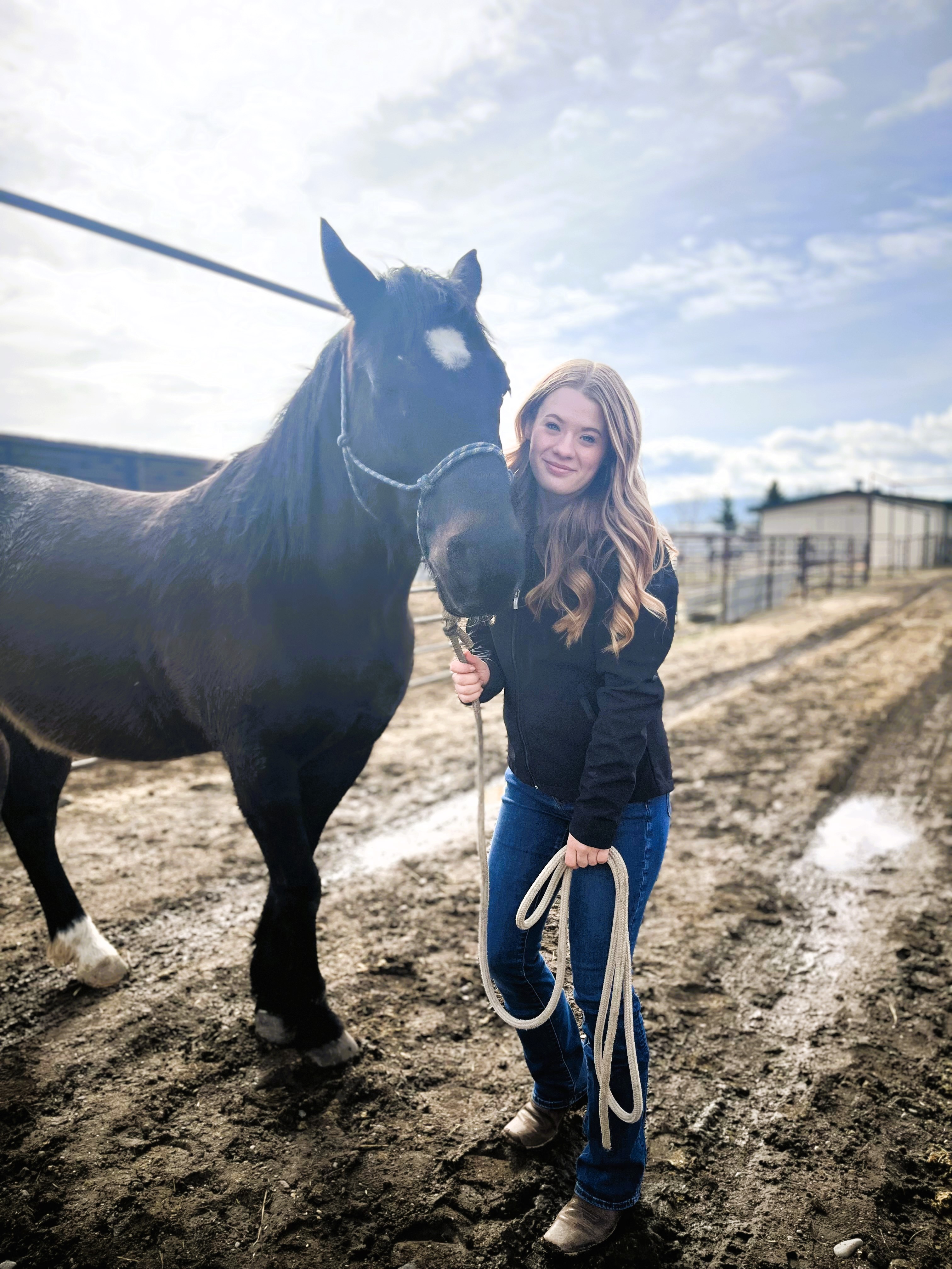 a young woman holding the reins of a horse