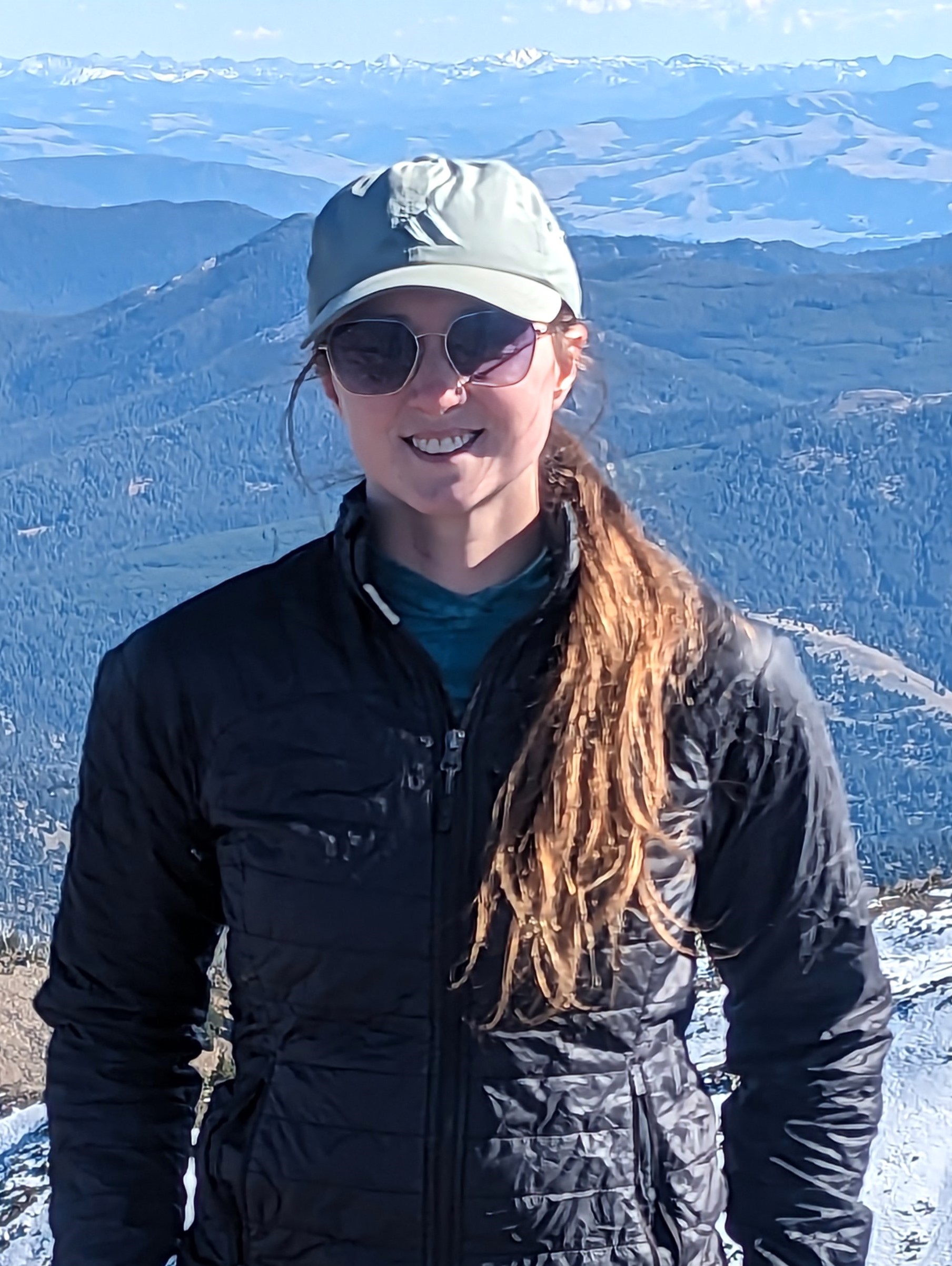 A woman in sunglasses in the mountains