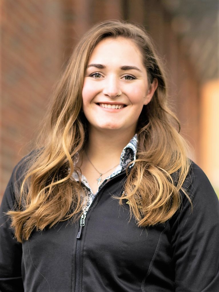 Smiling woman with long reddish-blonde hair wearing a college of ag ambassadors jacket