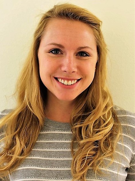 smiling woman with long wavy blonde hair wearing a striped shirt