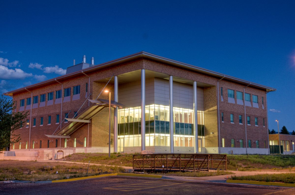 a three story brick building illuminated at night