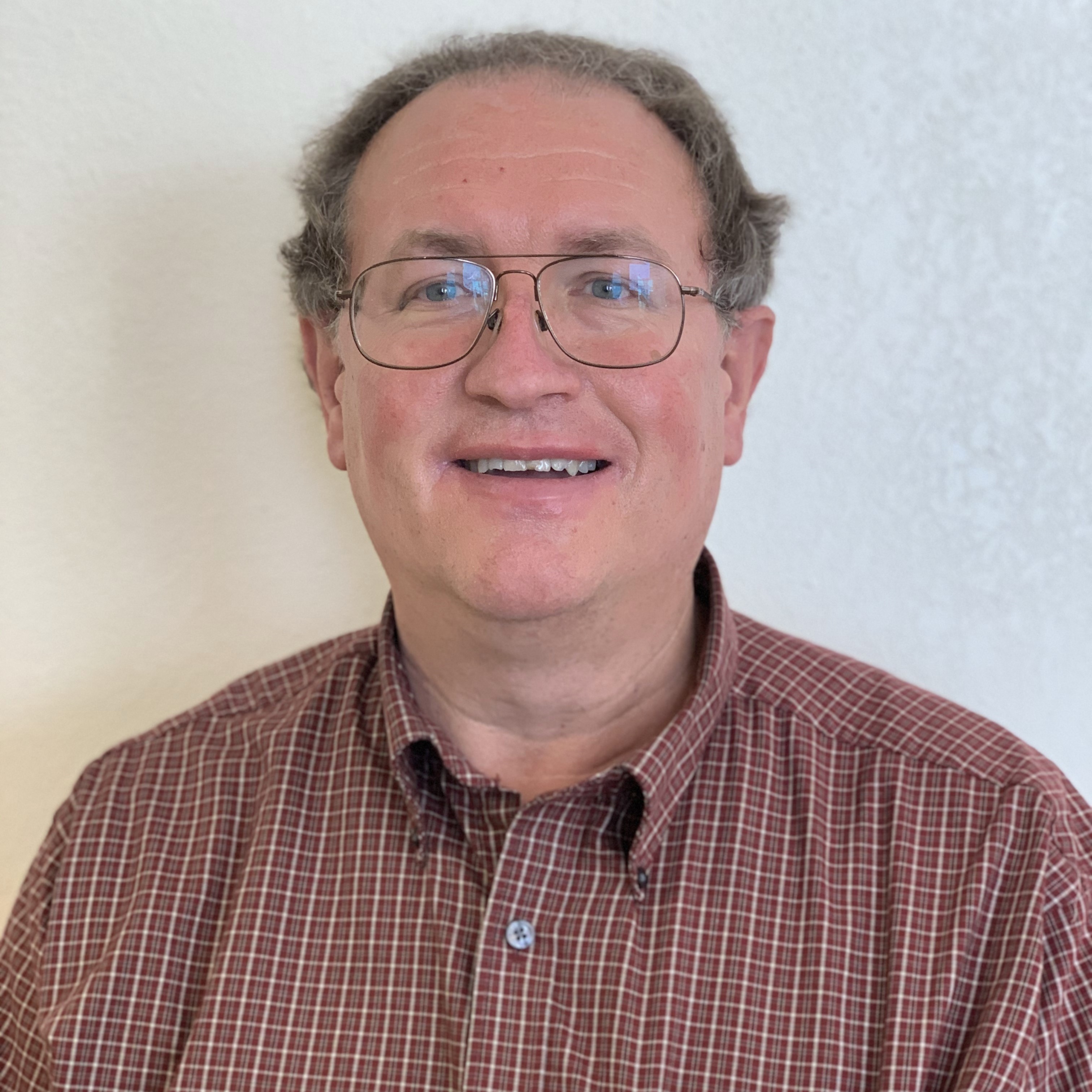A man with glasses and plaid shirt