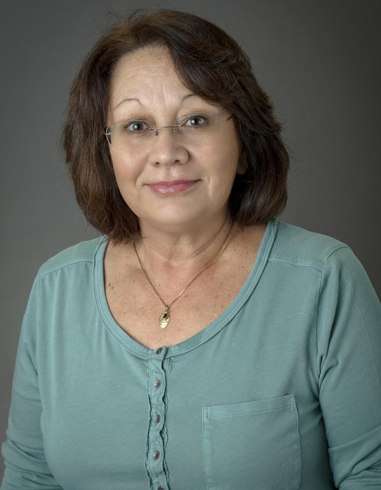 a woman with wavy brown hair and glasses